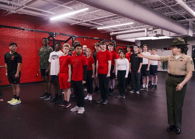 U.S. Marine Corps Staff Sgt. Katrina Jimenez, a senior drill instructor with Echo Company, 2nd Recruit Training Battalion, instruct poolees on close order drill during Recruiting Sub-Station Madison’s Drill Instructor Night at Milton High School, Milton WI, March 19, 2024. The purpose of Drill Instructor Night is to introduce poolees to incentive training, basic drill movements and give family and friends the opportunity to ask questions about recruit training and the Marine Corps. (U.S. Marine Corps photo by Cpl. Collette Hagen)