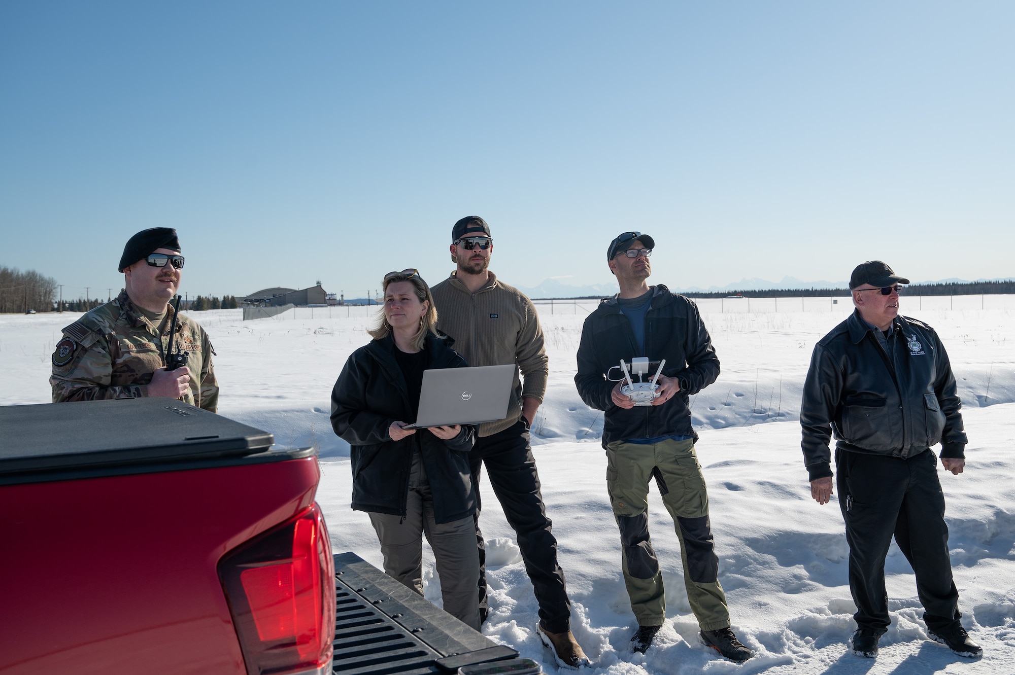Team members from the 354th Security Forces Squadron and Andural contracting team stand together and watch the drone test.