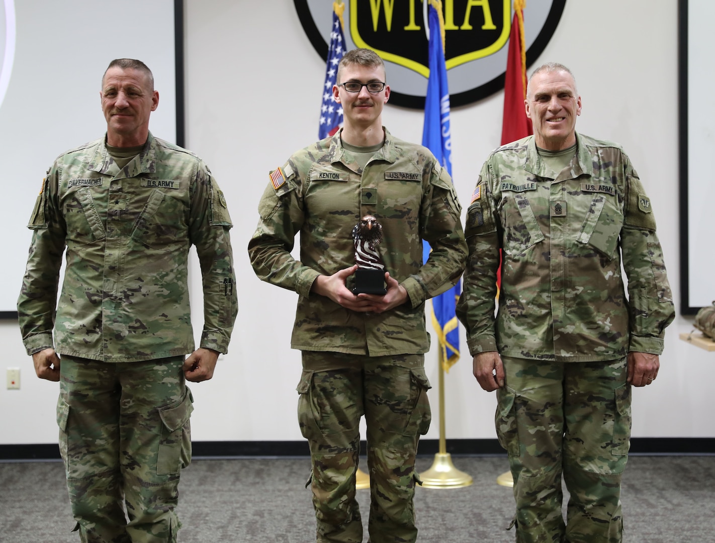 Spc. Tevin Kenton (center), a cavalry scout assigned to Charlie Troop, 1st Squadron, 105th Cavalry Regiment, 32nd Infantry Brigade Combat Team, poses with Brig. Gen. Daniel Pulvermacher (left), the assistant adjutant general for readiness and training for Army, and Command Sgt. Maj. Curtis Patrouille, the state senior enlisted leader (right), after receiving the award for Wisconsin Army National Guard Best Warrior Competition 2024 Soldier of the Year. (U.S. National Guard photo by Sgt. Payton Wehr)