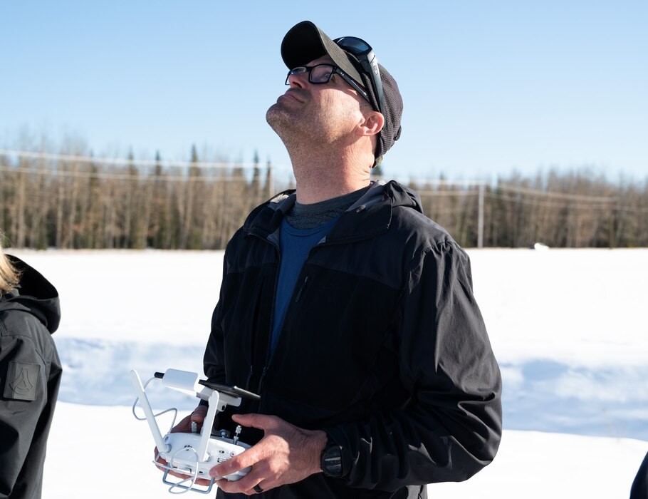 A contractor from Anduril uses a remote control to fly a drone during a drone test to evaluate the LRS T-82 long range sentry tower.