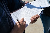 A photo of people taking notes on paper.
