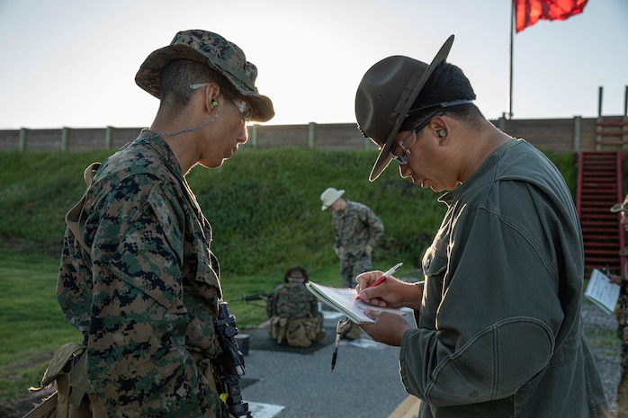 U.S. Marine Corps Primary Marksmanship Instructor Cpl. Aceves Isaac, discusses shot groupings with Recruit Damian Duran with Alpha Company, 1st Recruit Training Battalion, during the table one course of fire at Marine Corps Base Camp Pendleton, California, March 19, 2024. Table one is designed to introduce recruits to the basic fundamentals of marksmanship and rifle safety. (U.S. Marine Corps photo by Cpl. Sarah M. Grawcock)