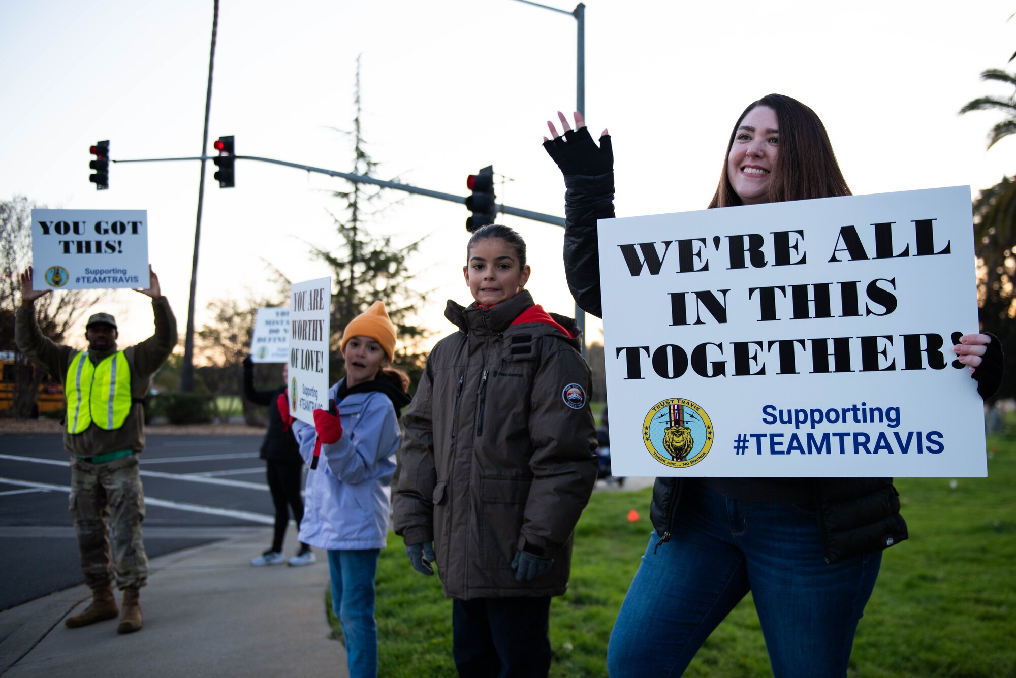 Volunteers hold signs.