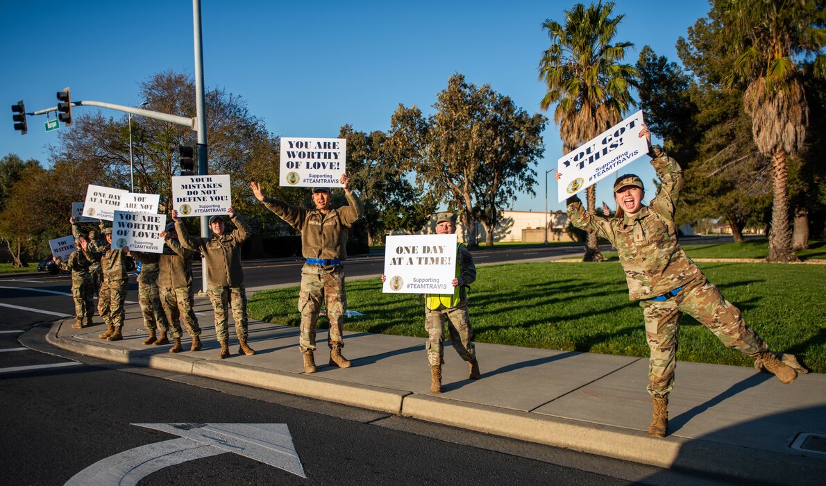 Volunteers hold signs.