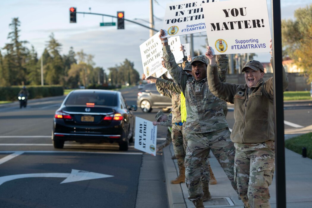 Volunteers hold signs.