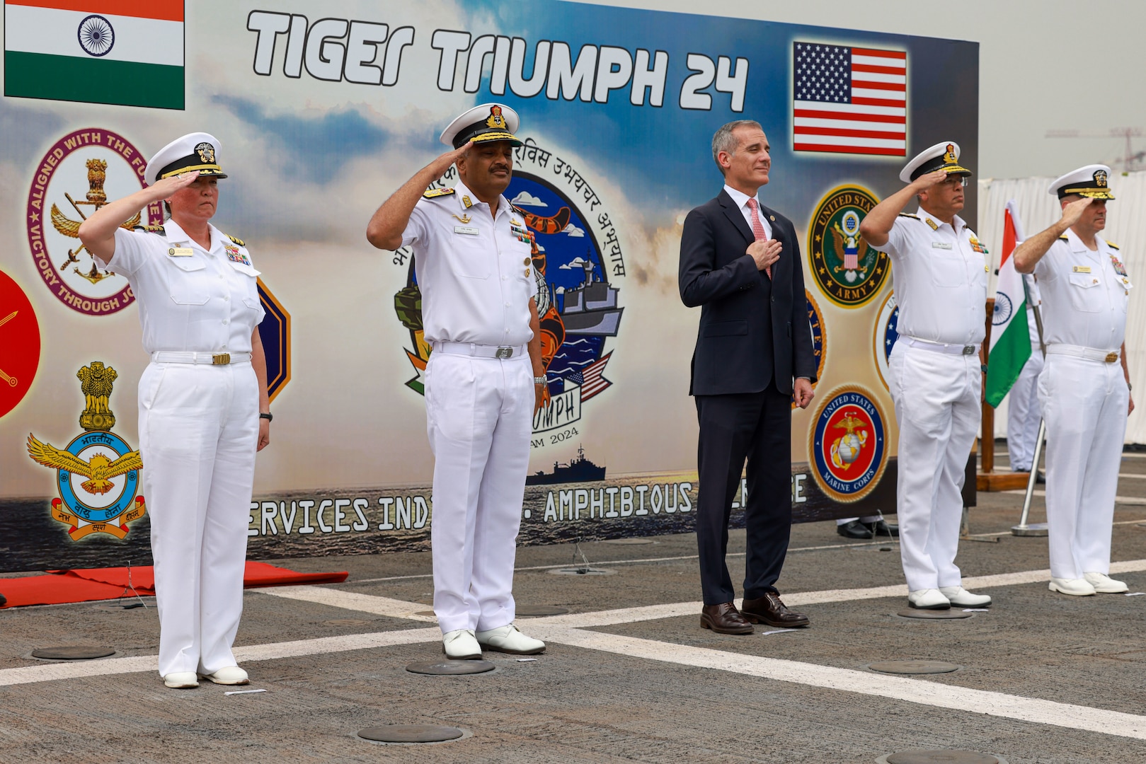 Distinguished visitors stand at attention for the playing of the U.S. and Indian national anthems during the opening ceremony of Exercise Tiger TRIUMPH in Visakhapatnam, India, March 19, 2024. Tiger TRIUMPH is a U.S.-India tri-service amphibious exercise focused on humanitarian assistance and disaster relief readiness and interoperability. Tiger TRIUMPH enables U.S. and Indian Armed Forces to improve interoperability and bilateral, joint, and service readiness in the Indian Ocean region and beyond to better achieve mutual regional security objectives. (U.S. Marine Corps photo by Cpl. Aidan Hekker)