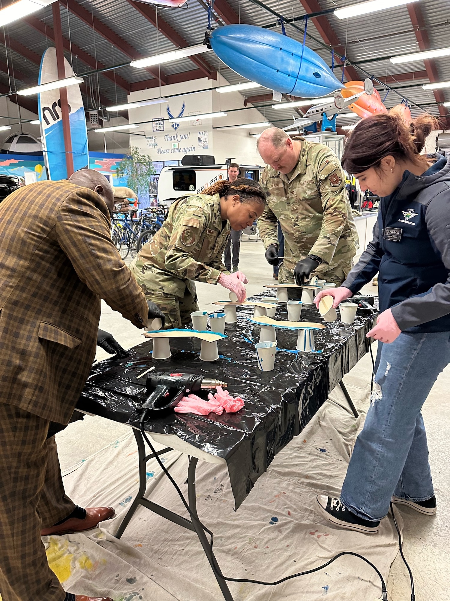 Chief Master Sgt. Tiffany Brown, Raymond Magby, and Col. Peter Olson, Maj. Gen. Eugene L. Eubank Award evaluators from Air Force Manpower, Personnel & Services learn how to create a Vandenberg-specific going away plaque at Vandenberg’s Outdoor Recreation facility with Lauren Pulido, 30th Force Support Squadron engraver at Vandenberg Space Force Base, Calif., March 19, 2024.  Vandenberg is one of two bases to be chosen as finalists to compete for the award.  (Courtesy Photo)