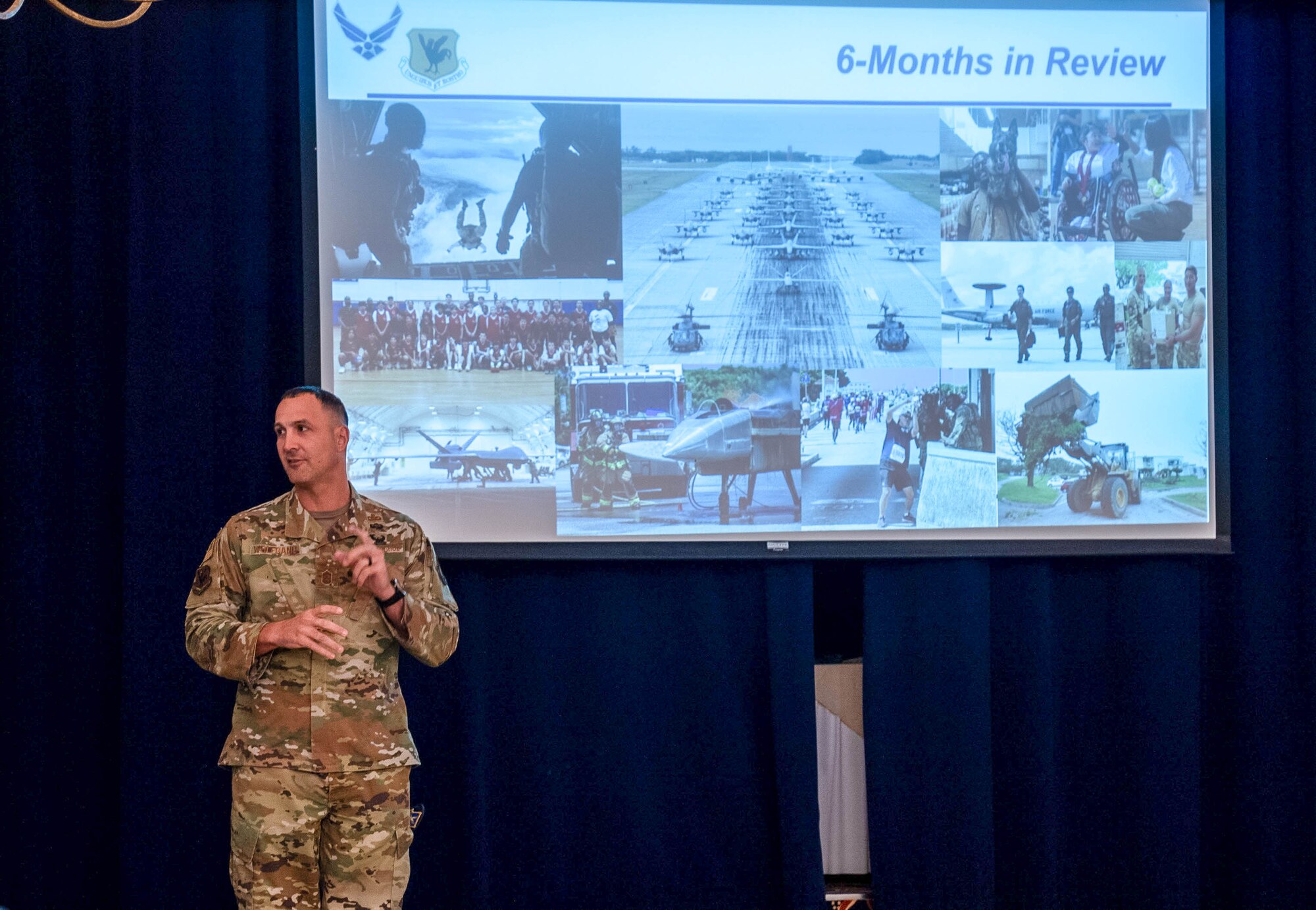 Airman speaks in front of a presentation slide