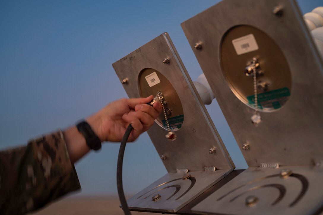 U.S. Space Force Tech Sgt. Kyle Yeager, flight chief of the 527 Space Aggressor Maintenance Flight and certified GPS operator, connects radio cables to the helical antenna in preparation for training exercise with the AC-130J Ghostrider at Cannon Air Force Base, New Mexico on March 5, 2024.