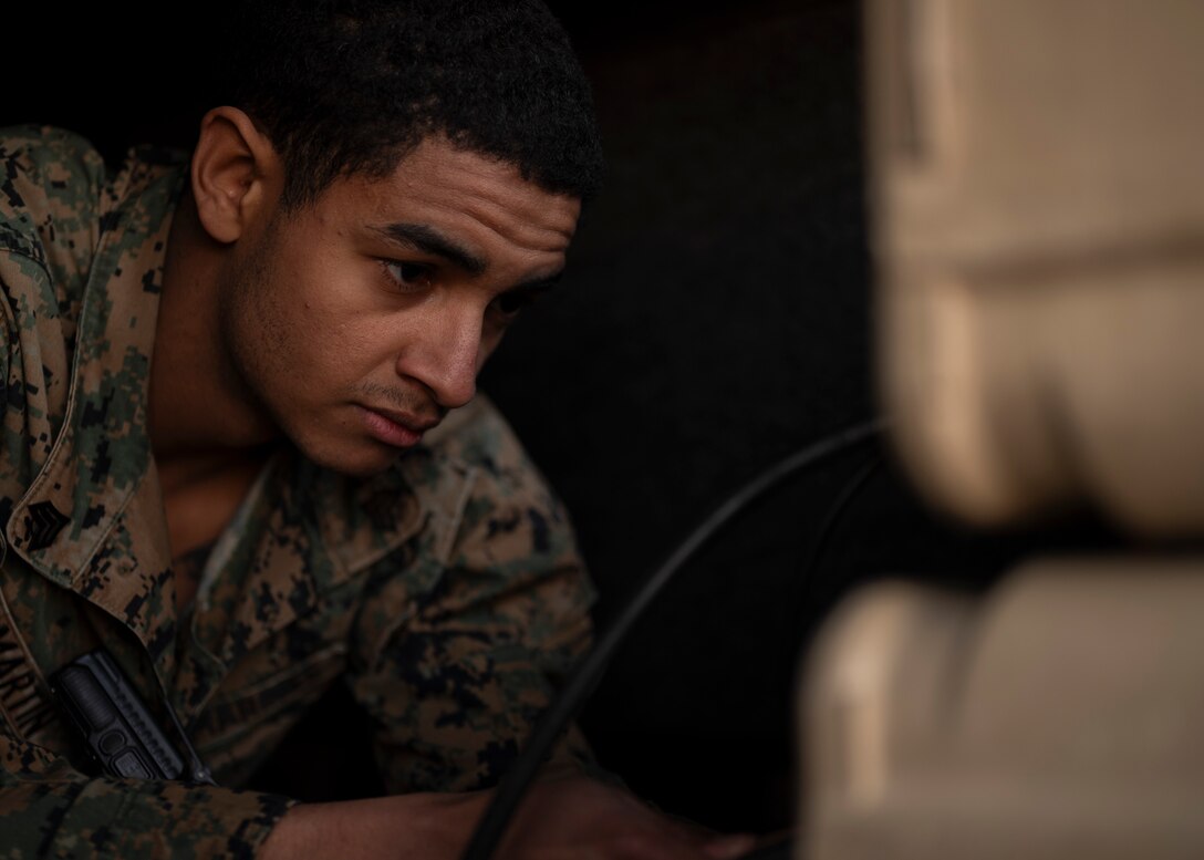 U.S. Marine Corps Staff Sgt. Devon Martin, signal warfare analyst 527 Space Aggressor Training Flight and certified GPS operator, connects radio cables to the electronic warfare equipment in preparation for training exercise with the AC-130J Ghostrider at Cannon Air Force Base, New Mexico on March 5, 2024.