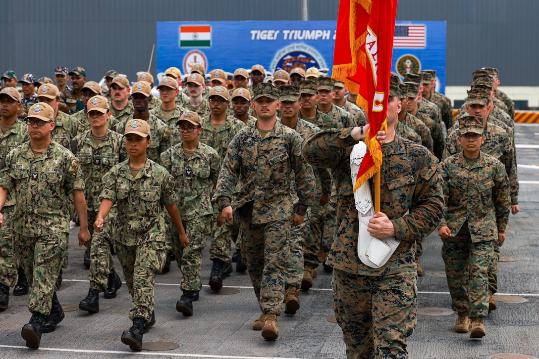 U.S. Marines assigned to the 15th Marine Expeditionary Unit and Sailors assigned to the amphibious transport dock USS Somerset (LPD 25) march during the opening ceremony of Exercise Tiger TRIUMPH in Visakhapatnam, India, March 19, 2024. Tiger TRIUMPH is a U.S.-India tri-service amphibious exercise focused on humanitarian assistance and disaster relief readiness and interoperability. Tiger TRIUMPH enables U.S. and Indian Armed Forces to improve interoperability and bilateral, joint, and service readiness in the Indian Ocean region and beyond to better achieve mutual regional security objectives. (U.S. Marine Corps photo by Cpl. Aidan Hekker)