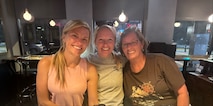 Three females pose together in a restaurant