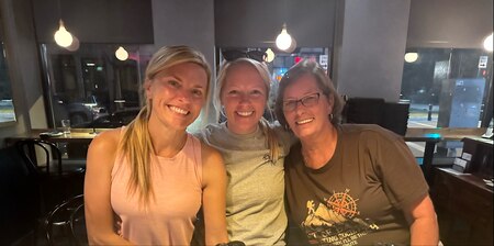 Three females pose together in a restaurant