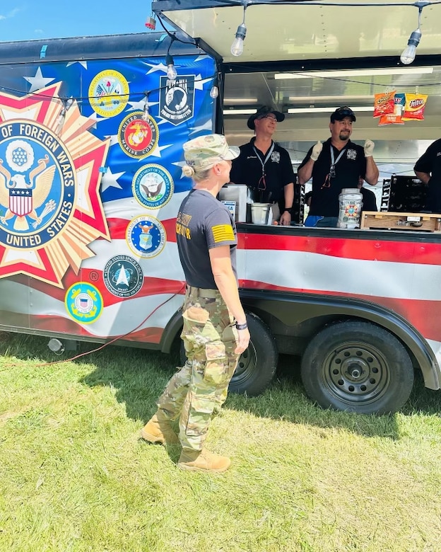 Female Soldier ordering food from a Veterans of Foreign Wars booth