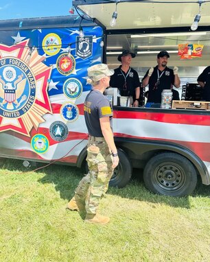 Female Soldier ordering food from a Veterans of Foreign Wars booth