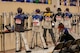 Women in shooting uniform standing with air rifle.