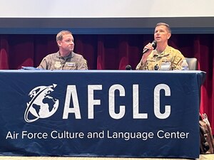 Two panel members sit at table.