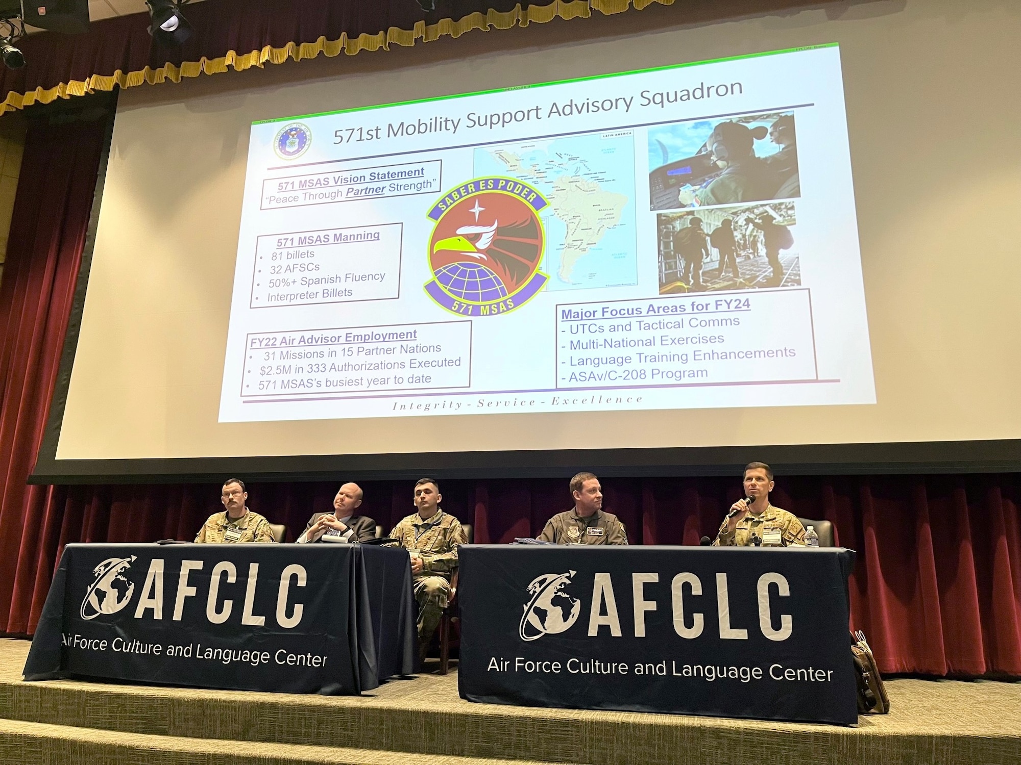 Members of a panel sit at tables.