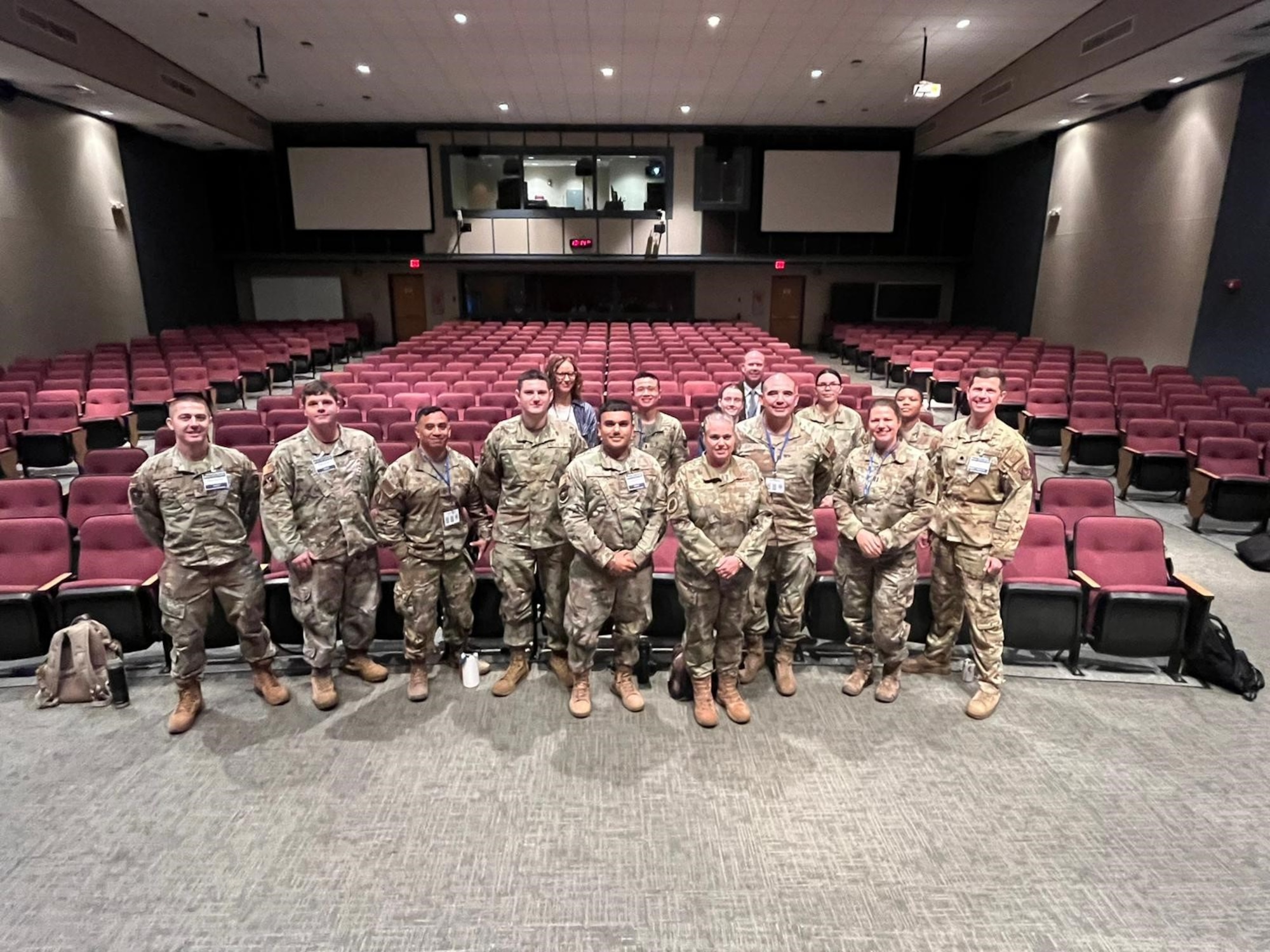 A group stands for a photo in auditorium.