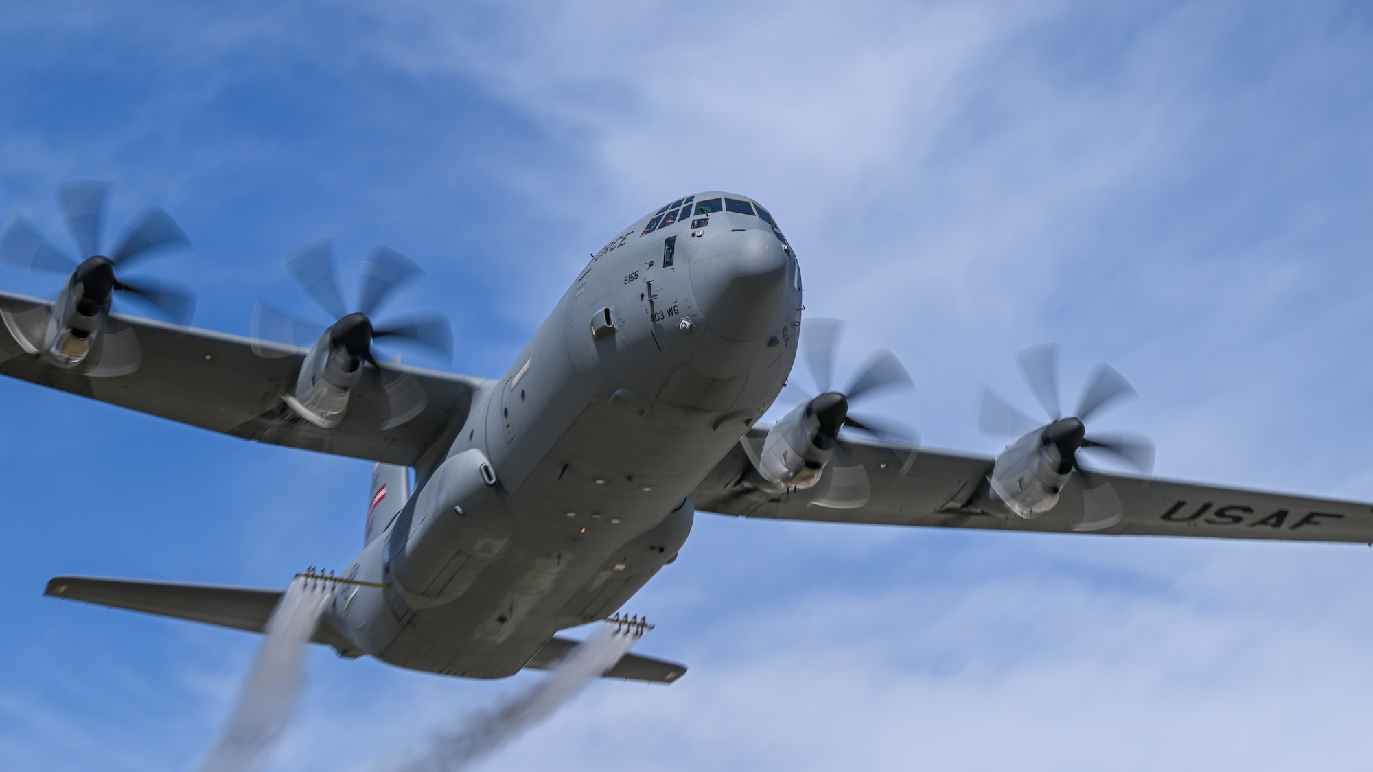 A C-130J-30 Super Hercules aircraft from Keesler Air Force Base, Mississippi, sprays water during a low pass at Youngstown Air Reserve Station, Ohio, as part of a flight test of the 910th Airlift Wing's unique electronic modular aerial spray system, March 25, 2024. The flight test was performed to ensure the operability of the spray system aboard the airframe as the 910th prepares to upgrade its aging C-130H Hercules fleet to new J-30 models. The project was carried out in partnership between 910th Airlift Wing maintenance personnel and aerial spray specialists, members of the Warner Robins Air Logistics Complex C-130 System Program Office, Georgia, and test flight aircrew from the Little Rock Air Force Base, Arkansas. (U.S. Air Force photo by Eric M. White)