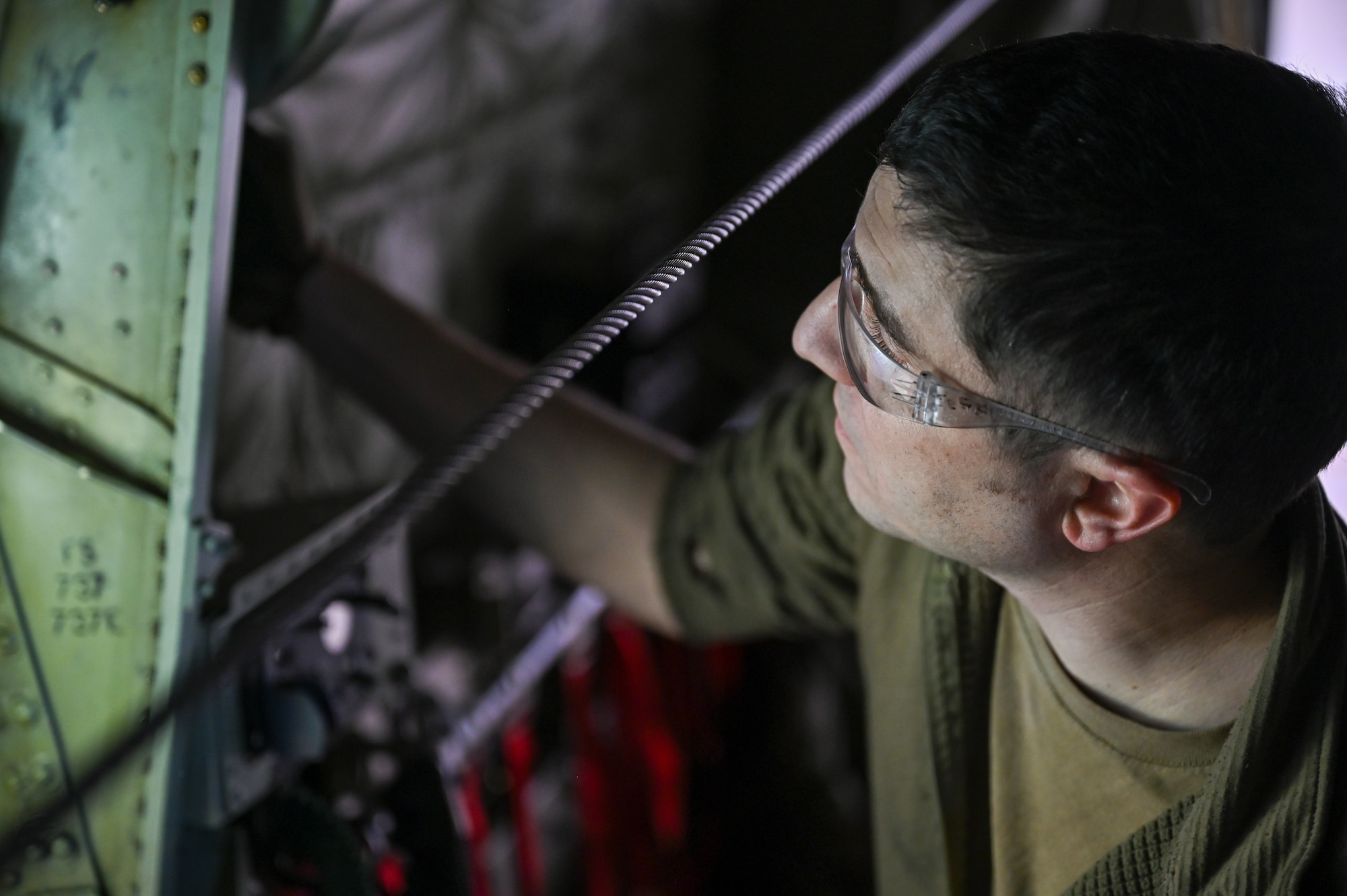 Master Sgt. Jeff McGhee, an aerospace maintainer with the 910th Maintenance Squadron, loosens a troop door on a C-130J-30 Super Hercules aircraft from Keesler Air Force Base, Mississippi, visiting Youngstown Air Reserve Station, Ohio, March 19, 2024.