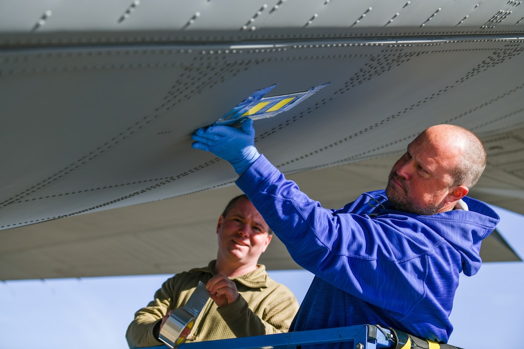 Matthew Kilmer, a C-130 system engineer from the Air Logistics Complex C-130 System Program Office at Warner Robins Air Force Base, Georgia, fastens a droplet sample card to the tail of a C-130J-30 Super Hercules aircraft at Youngstown Air Reserve Station, Ohio, March 25, 2024.