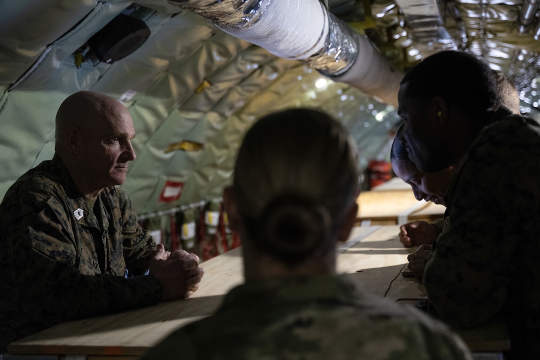 Military members talk on board a plane.