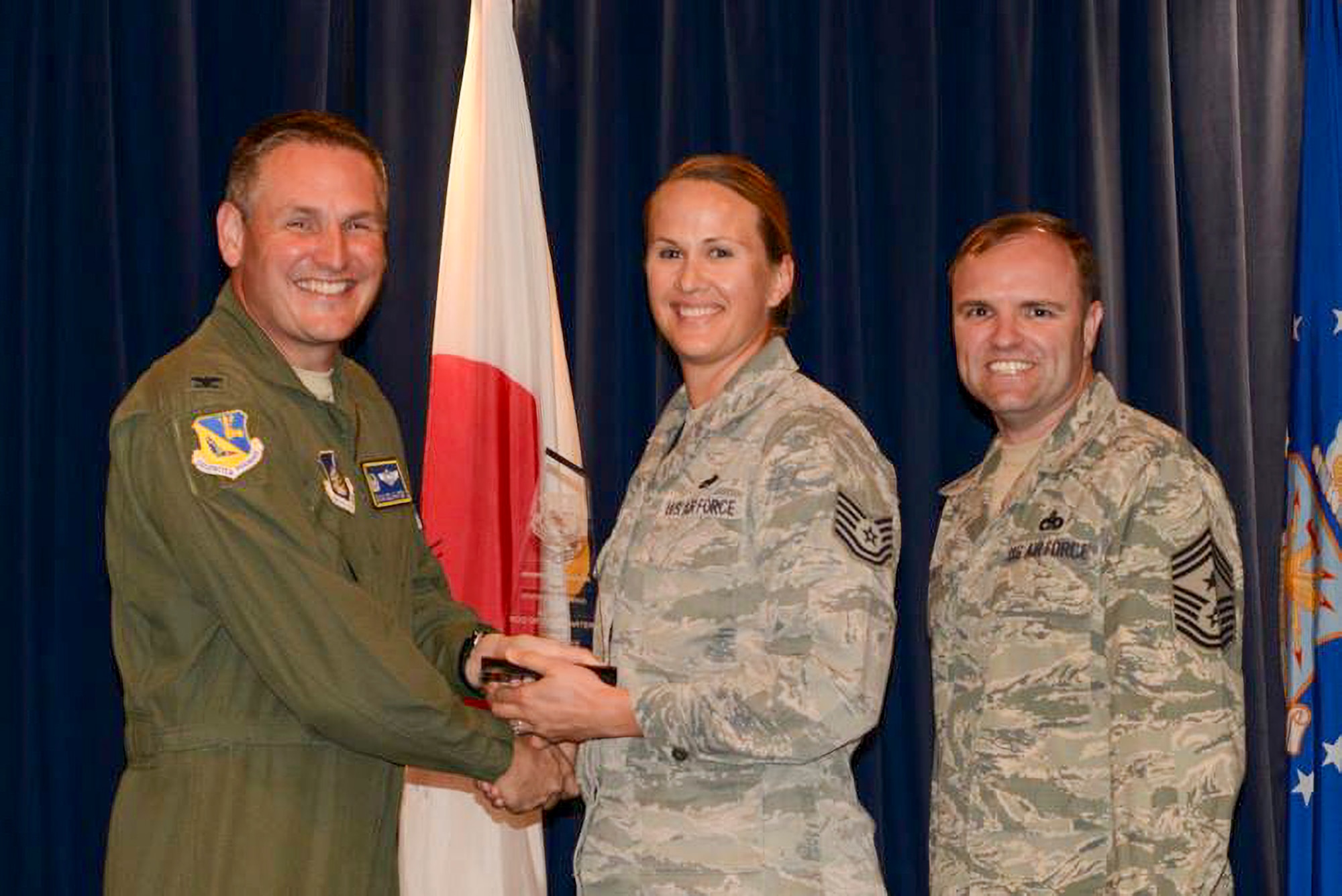 Tech. Sgt. Jennifer Barger, 374th Aircraft Maintenance Squadron crew chief, is awarded wing Non-Commissioned Officer of the quarter by Col. Douglas DeLaMater, 374th Airlift Wing commander, at Yokota Air Base, Japan, 2015.