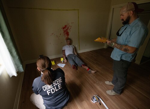 Contestants evaluate mock crime scene