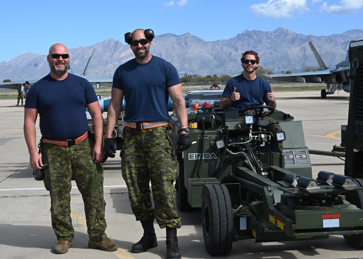 Royal Canadian air force Master Cpl. Denis, left, and Cpl. Bandeira, right, 425th Tactical Fighter Squadron air weapons system technicians, loads a bomb during Exercise Cougar South at Davis-Monthan Air Force Base, Ariz., March 14, 2024. DM supported the RCAF, which strengthened the Northern Atlantic Treaty Organization. (U.S. Air Force photo by Staff Sgt. Abbey Rieves)