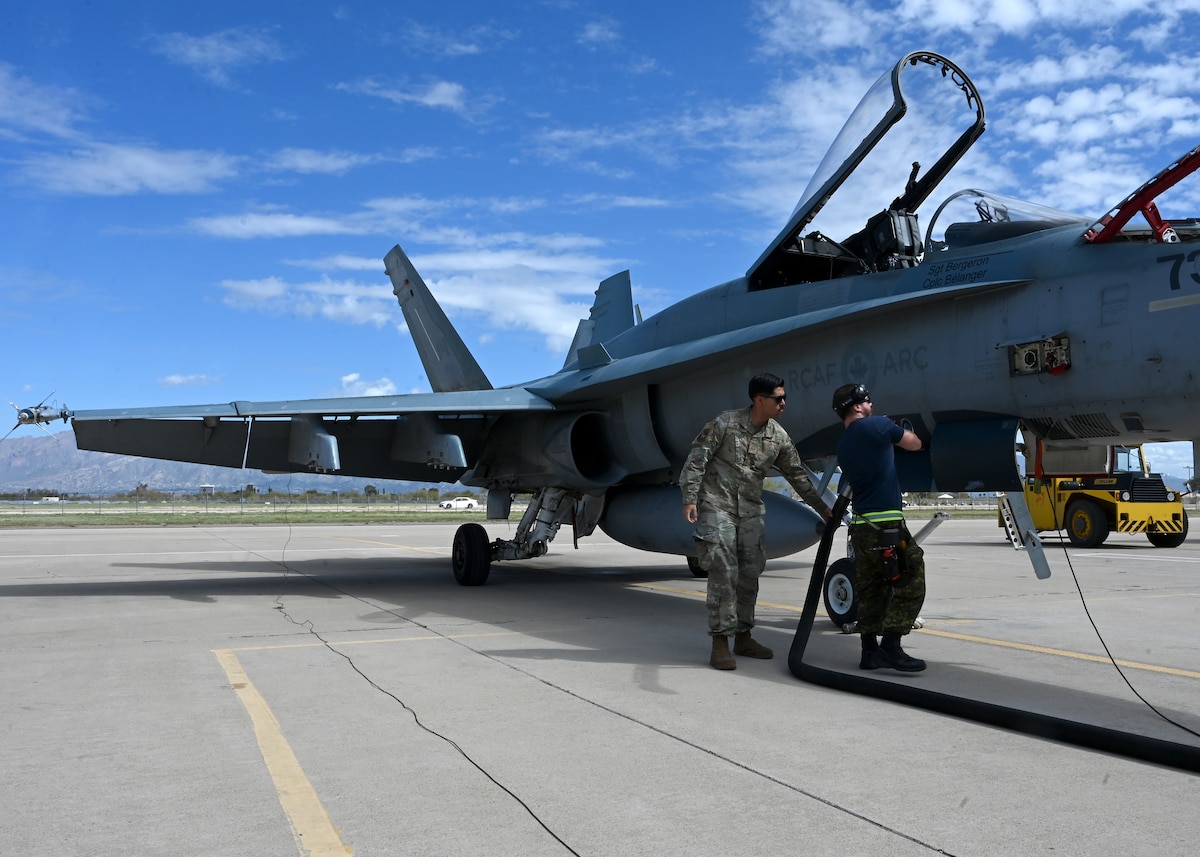 U.S. Air Force Senior Airman Luis Pulido, 355th Logistics Readiness Squadron petroleum, oils and lubricants technician, left, and Royal Canadian air force Cpl. Taillerfer, 425th Tactical Fighter Squadron avionic systems technician, fuel a RCAF CF-18 Hornet aircraft during Exercise Cougar South at Davis-Monthan Air Force Base, Ariz., March 14, 2024. ECS was a high-tempo, large-scale exercise intended to increase the RCAF’s fighter force readiness and maintain tactical fighter interoperability between the RCAF and the U.S. Air Force. (U.S. Air Force photo by Staff Sgt. Abbey Rieves)