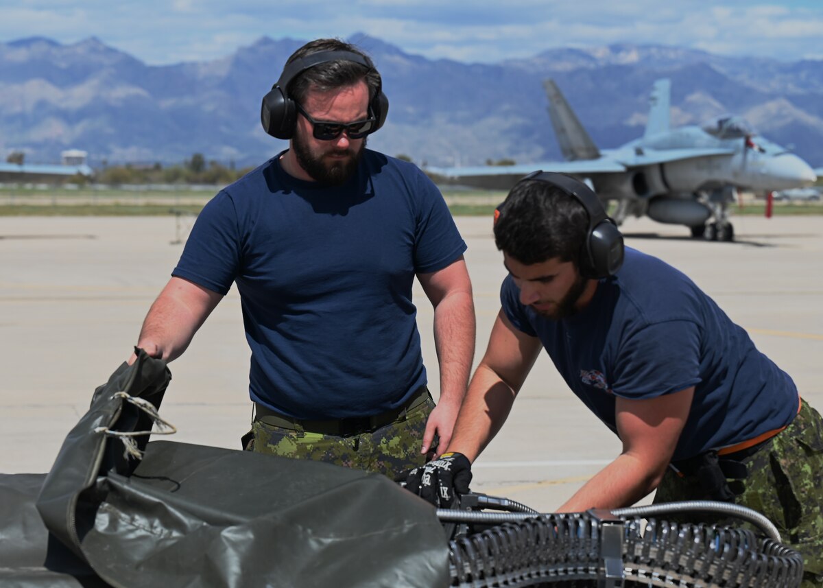 Royal Canadian air force weapon technicians arm a CF-18 Hornet aircraft during Exercise Cougar South at Davis-Monthan Air Force Base, Ariz., March 14, 2024. DM trained the RCAF to uphold its primary mission of deploying, employing and sustaining combat search and rescue, attack airpower in support of combatant commanders anywhere in the world. (U.S. Air Force photo by Staff Sgt. Abbey Rieves)