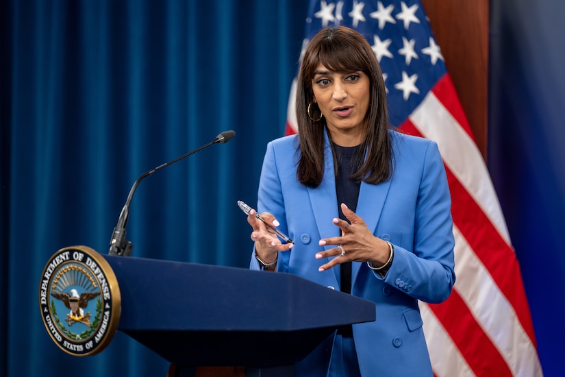 A woman stands behind a lectern.