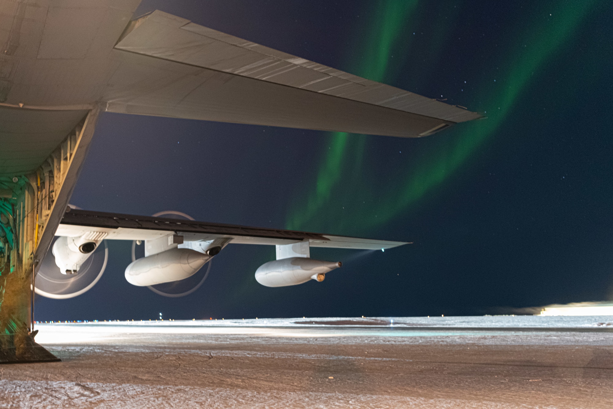 An MC-130J Commando II assigned to the 27th Special Operations Wing, is parked on the runway with the Northern Lights overhead during Arctic Edge 24 in Utqiagvik, Alaska, Feb. 29, 2024. Arctic Edge 24 provides Special Operations Command North the opportunity to test a range of capabilities and response options to deter, disrupt, degrade, and deny competitor activity in the Arctic in support of globally integrated layered defense and deterrence of the homeland. (U.S. Air Force photo by Senior Airman Drew Cyburt)