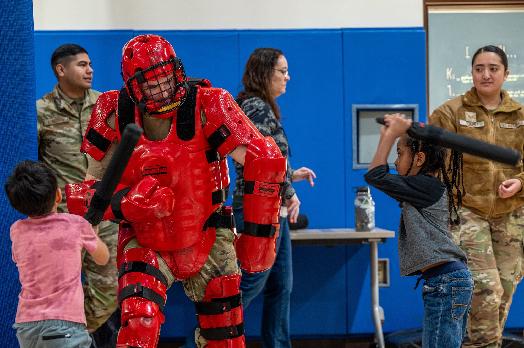 51st Security Forces Squadron Defenders demonstrate the Red Man XP Instructor Suit to Osan Elementary School students during career day at Osan Air Base, Republic of Korea, March 15, 2024. During the event, volunteers spoke about their careers and showcased equipment used for their duties. The event aimed to illustrate future career paths in and outside of the military to OES students. (U.S. Air Force photo by Airman 1st Class Chase Verzaal)