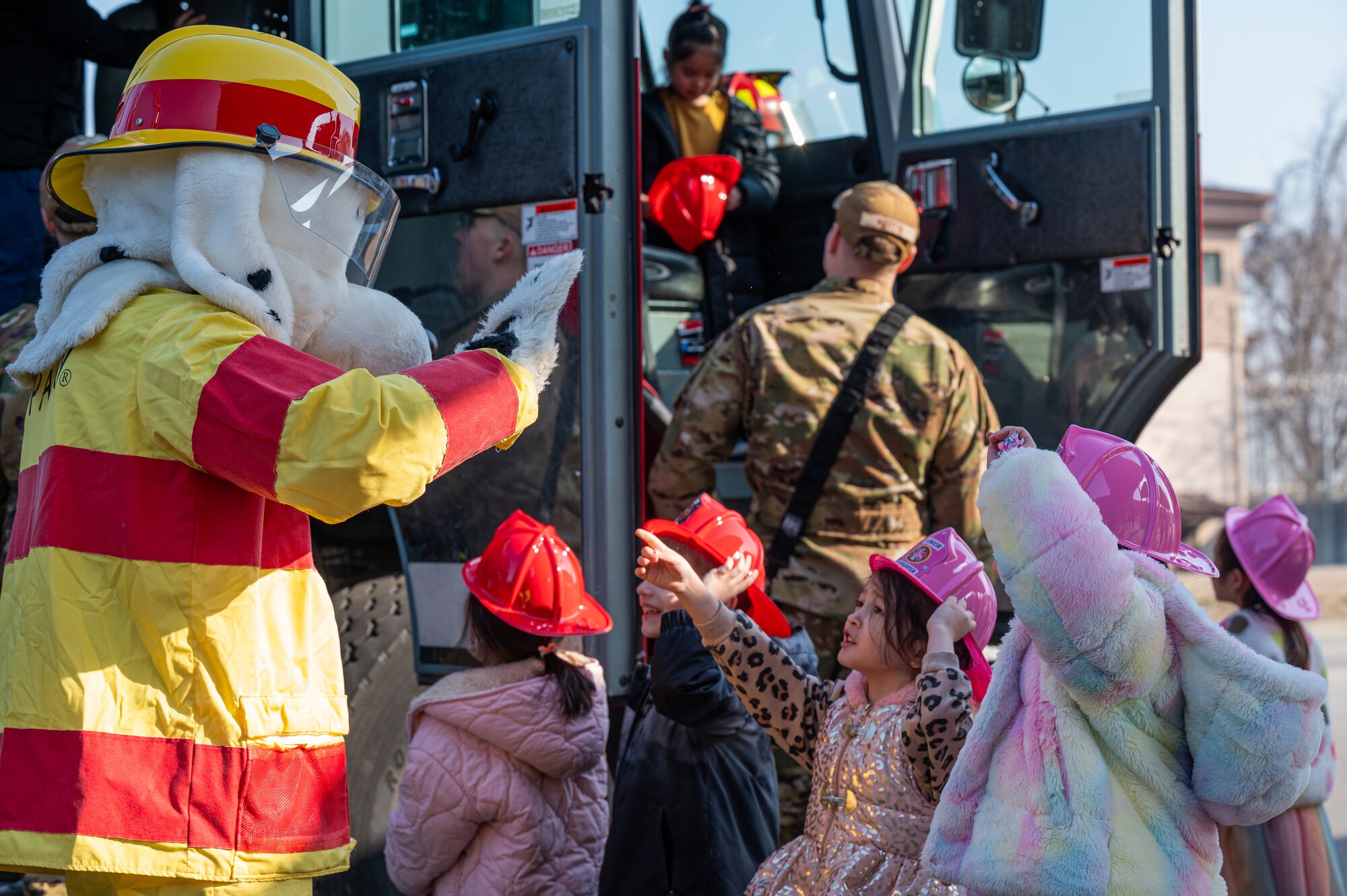 51st Civil Engineer Squadron firefighters and Sparky the Fire Dog interact with children from Osan Elementary School during career day at Osan Air Base, Republic of Korea, March 15, 2024. Over 30 volunteers dedicated their time to providing information to OES students, giving them options for career paths that they could strive for in the future. (U.S. Air Force photo by Airman 1st Class Chase Verzaal)