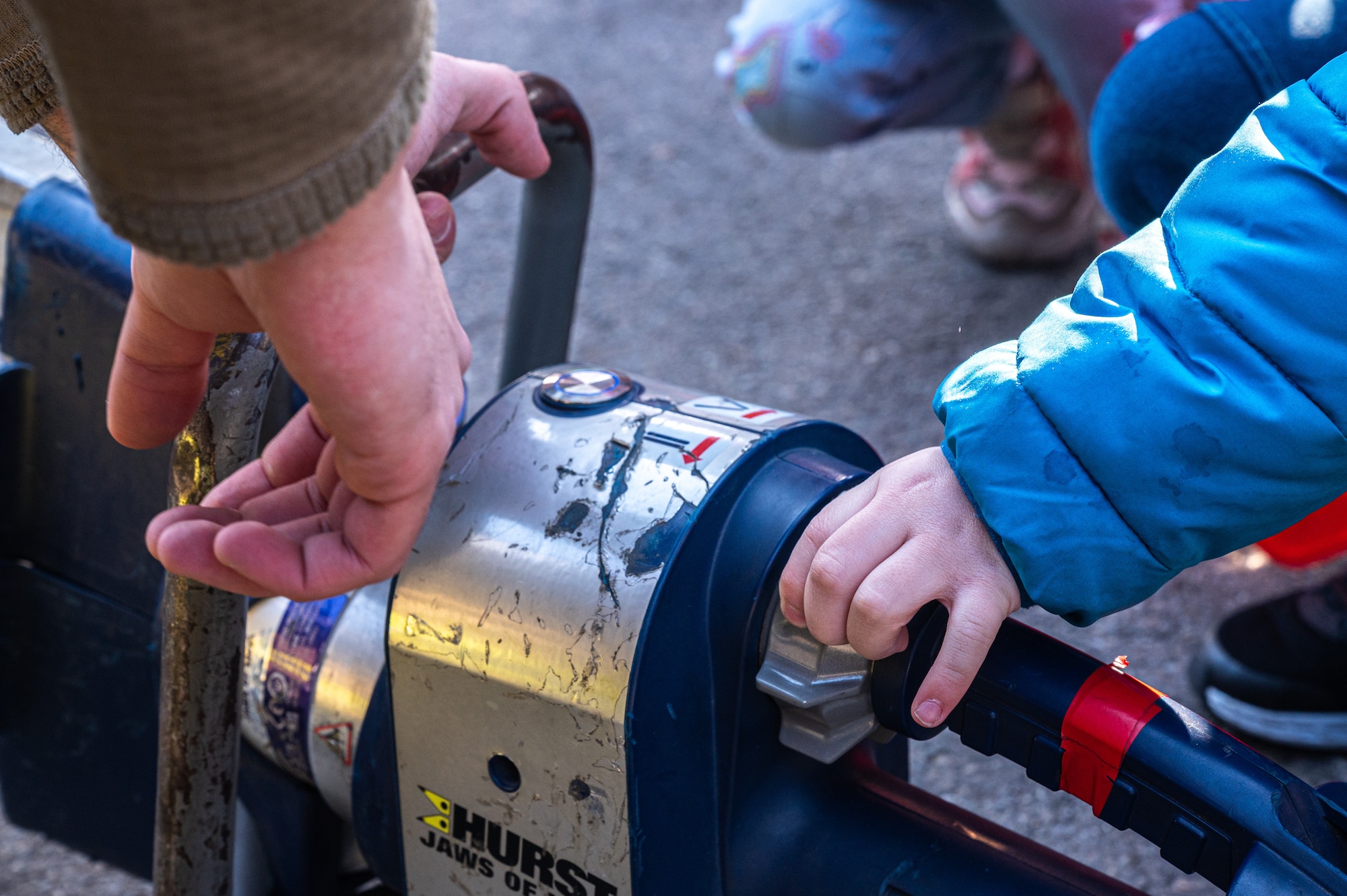 A 51st Civil Engineer Squadron firefighter helps Osan Elementary School children operate the Jaws of Life during career day at Osan Air Base, Republic of Korea, March 15, 2024. Career day showcased future opportunities to OES students, and educated them on various careers in the military. (U.S. Air Force photo by Airman 1st Class Chase Verzaal)