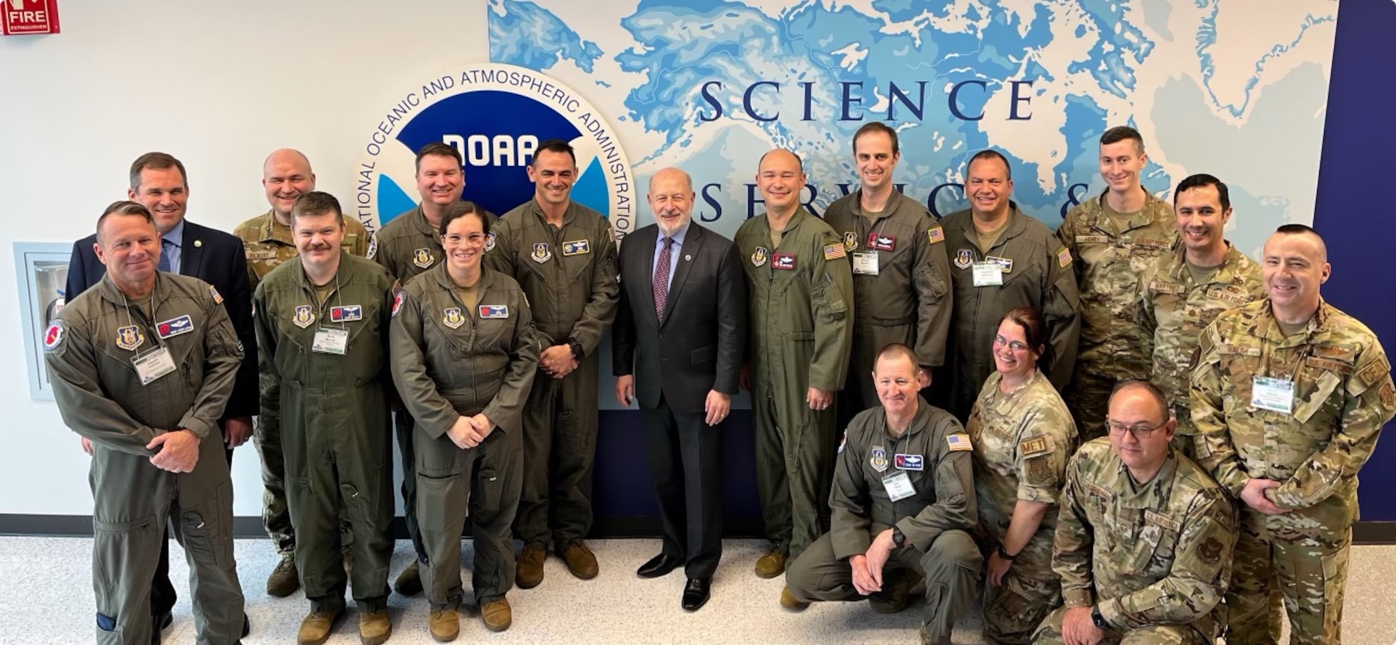 Air Force Reserve members and NOAA members pose in a group photo during a conference.