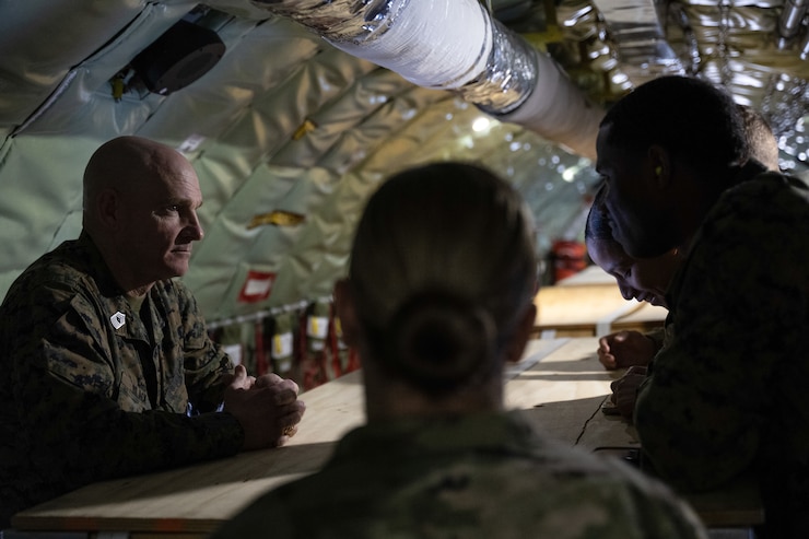 Military service members speak at a table