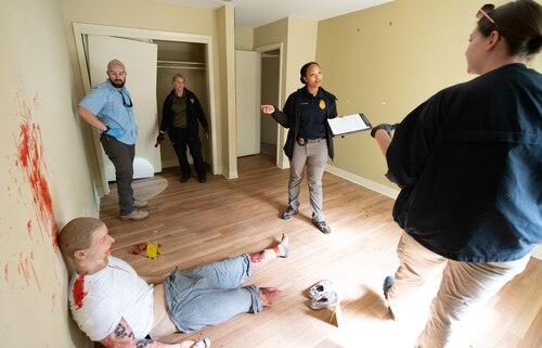 Contestants evaluate mock crime scene