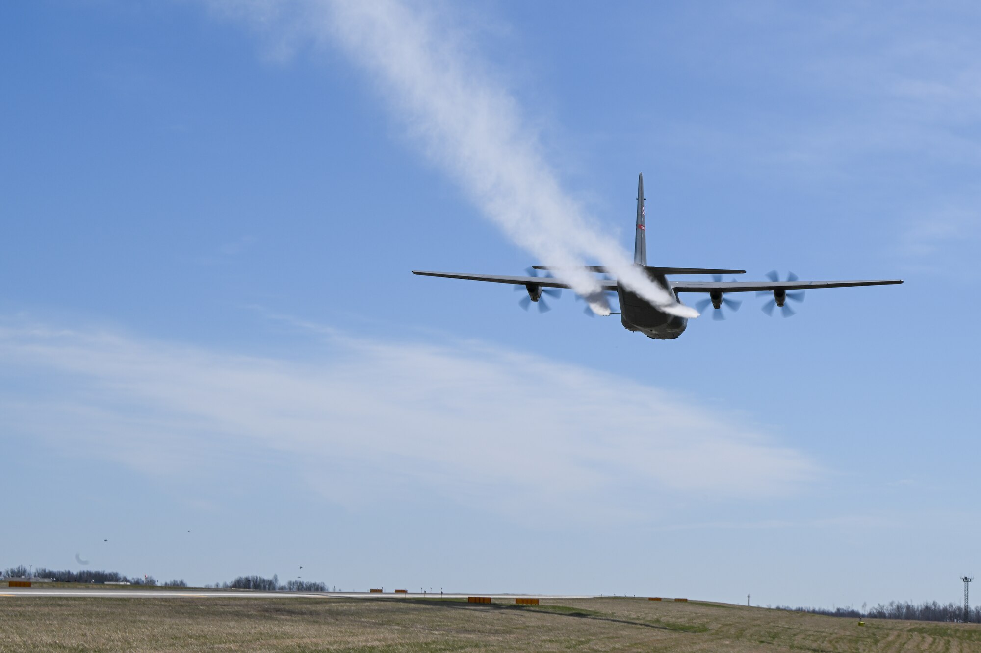 A C-130J-30 Super Hercules aircraft from Keesler Air Force Base, Mississippi, sprays water during a low pass at Youngstown Air Reserve Station, Ohio, as part of a flight test of the 910th Airlift Wing's unique electronic modular aerial spray system, March 25, 2024.