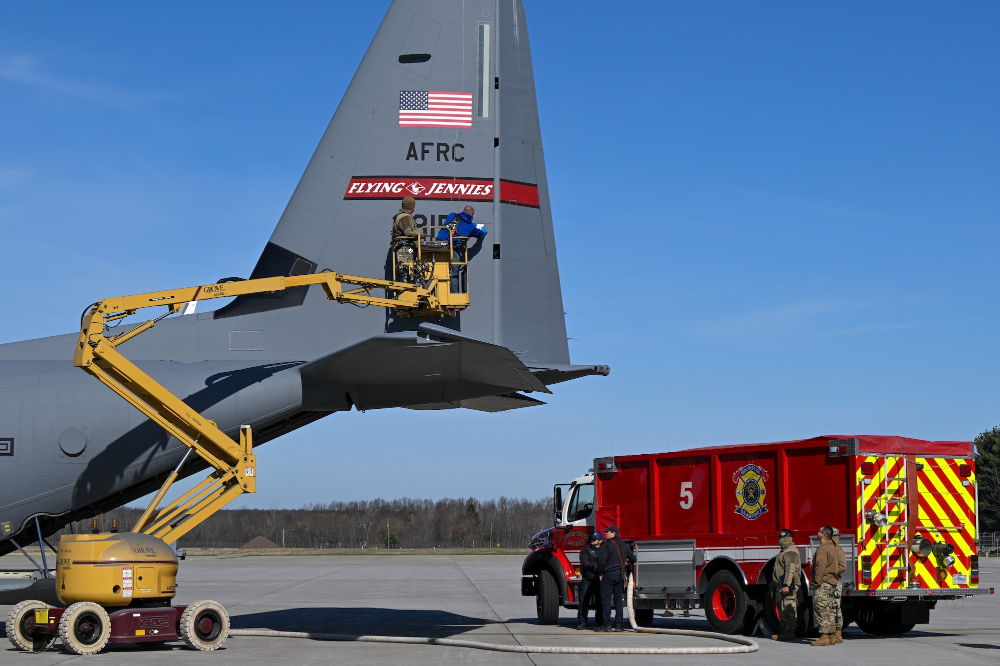 Matthew Kilmer, a C-130 system engineer from the Warner Robins Air Logistics Complex System Program Office, Georgia, fastens a droplet sample card to the tail of a C-130J-30 Super Hercules aircraft at Youngstown Air Reserve Station, Ohio, March 25, 2024, as the base fire department supplies water to the on-board electronic modular aerial spray system.