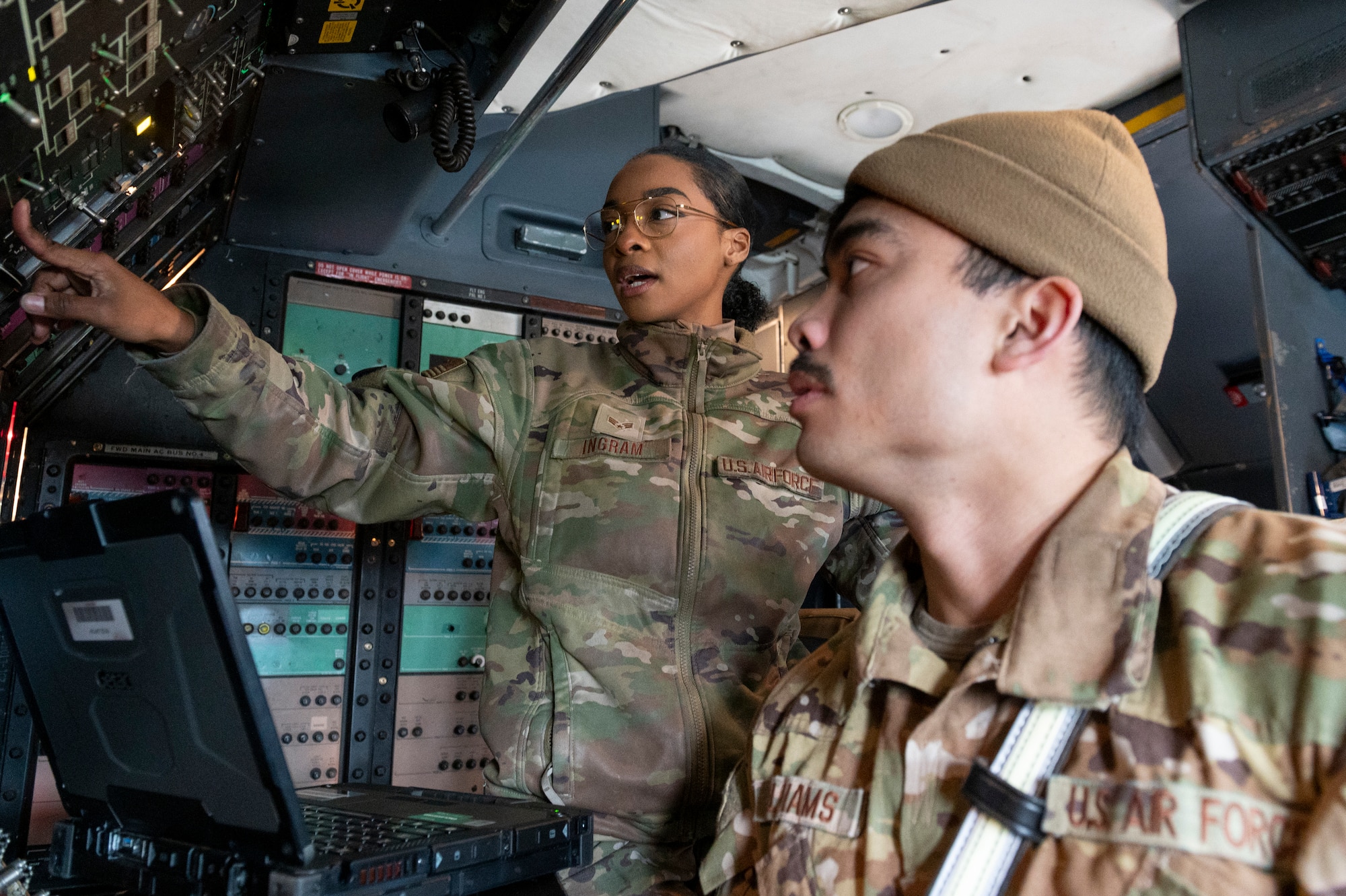 Senior Airman Jamie Ingram, 730th Air Mobility Squadron shows Senior Airman Anthon Williams, 374th Civil Engineer Squadron firefighter a control switch inside a C-5M Super Galaxy, assigned to the 60th Air Mobility Wing, Travis Air Force Base, CA, at Yokota Air Base.