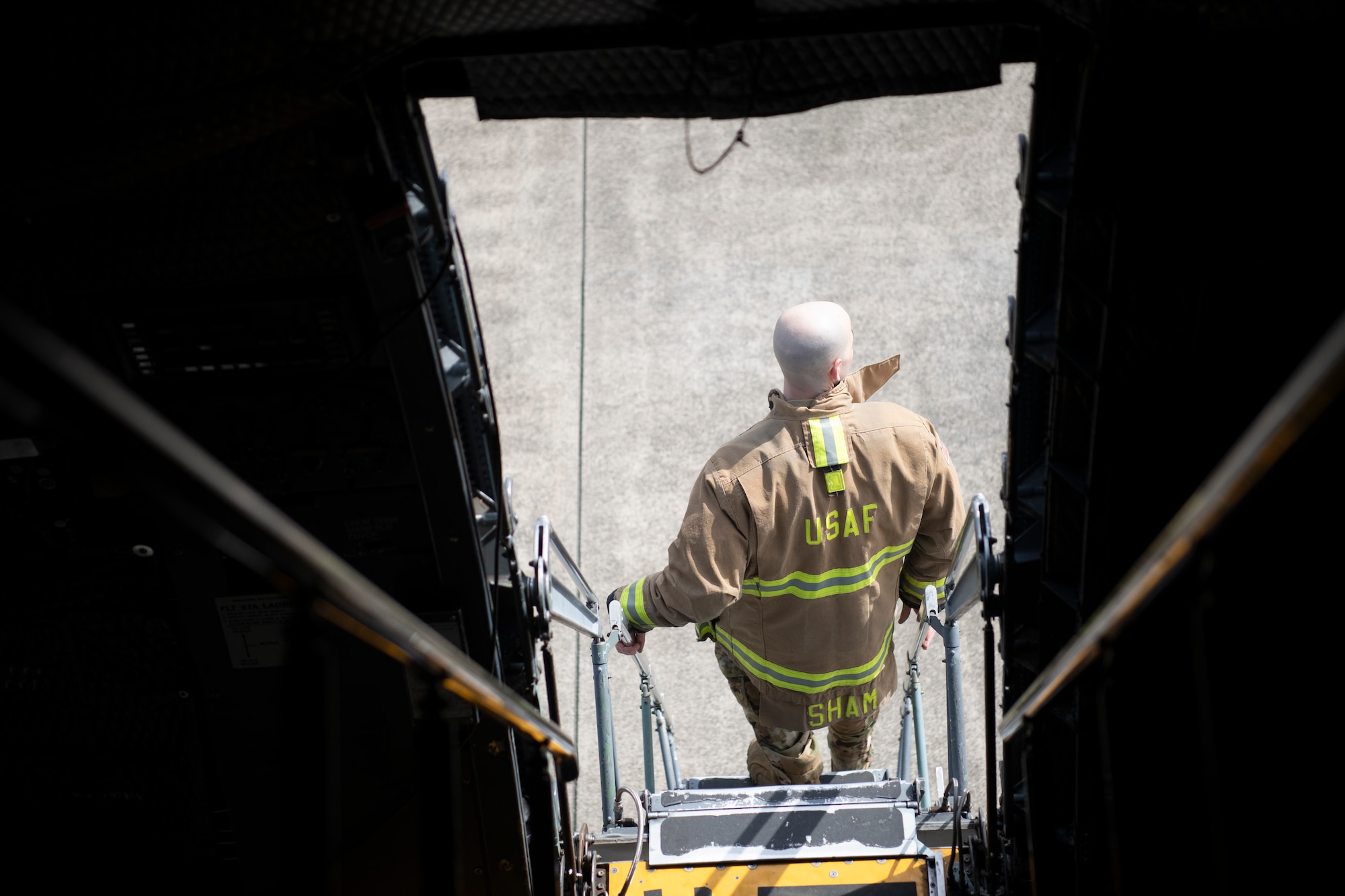 A firefighter exits a C-5M Super Galaxy, assigned to the 60th Air Mobility Wing, Travis Air Force Base, CA, during egress training.