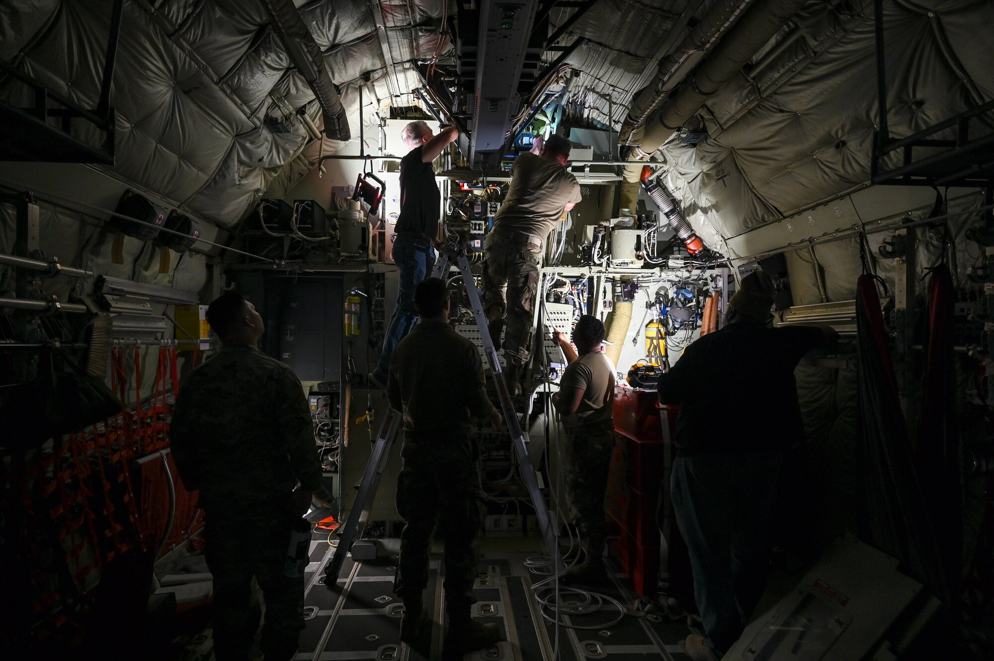 Aircraft electrical and environmental systems specialists assigned to the 910th Maintenance Squadron and members from the Warner Robins Air Logistics Complex C-130 System Program Office, Georgia, modify the electrical system of a C-130J-30 Super Hercules aircraft from Keesler Air Force Base, Mississippi, visiting Youngstown Air Reserve Station, Ohio, March 19, 2024.