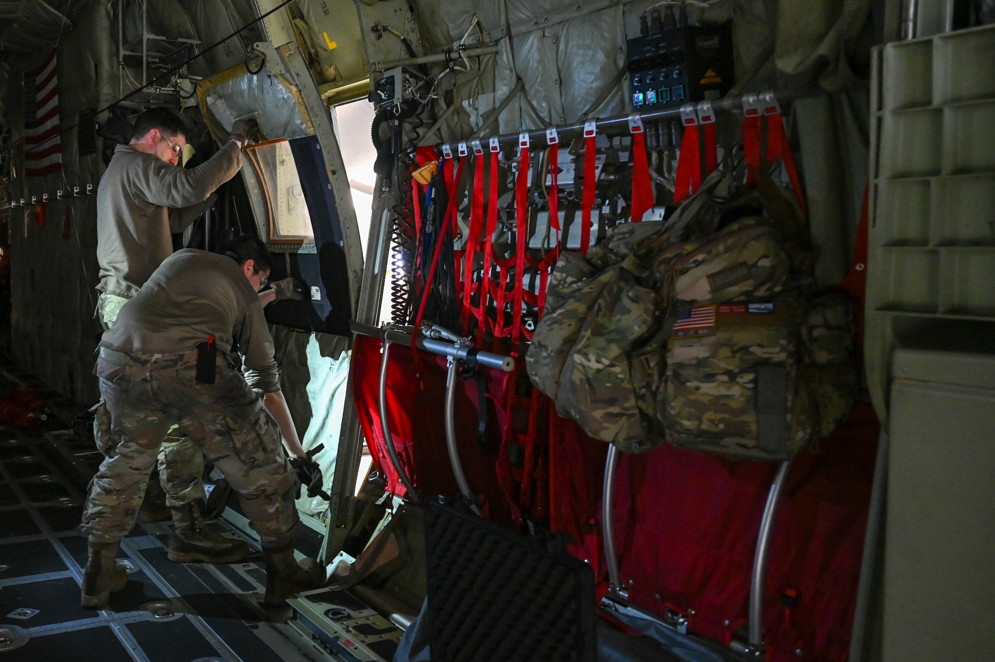 Master Sgt. Jeff McGhee and Senior Airman Khala Walls, aerospace maintainers with the 910th Maintenance Squadron, remove a troop door from a C-130J-30 Super Hercules aircraft from Keesler Air Force Base, Mississippi, visiting Youngstown Air Reserve Station, Ohio, March 19, 2024.