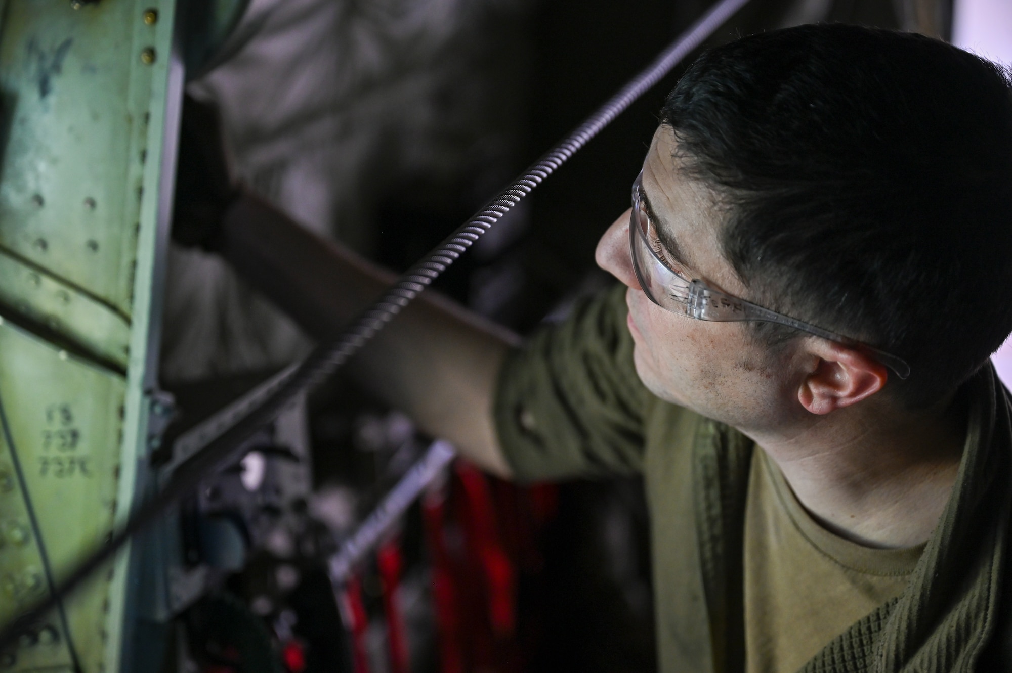 Master Sgt. Jeff McGhee, an aerospace maintainer with the 910th Maintenance Squadron, loosens a troop door on a C-130J-30 Super Hercules aircraft from Keesler Air Force Base, Mississippi, visiting Youngstown Air Reserve Station, Ohio, March 19, 2024.