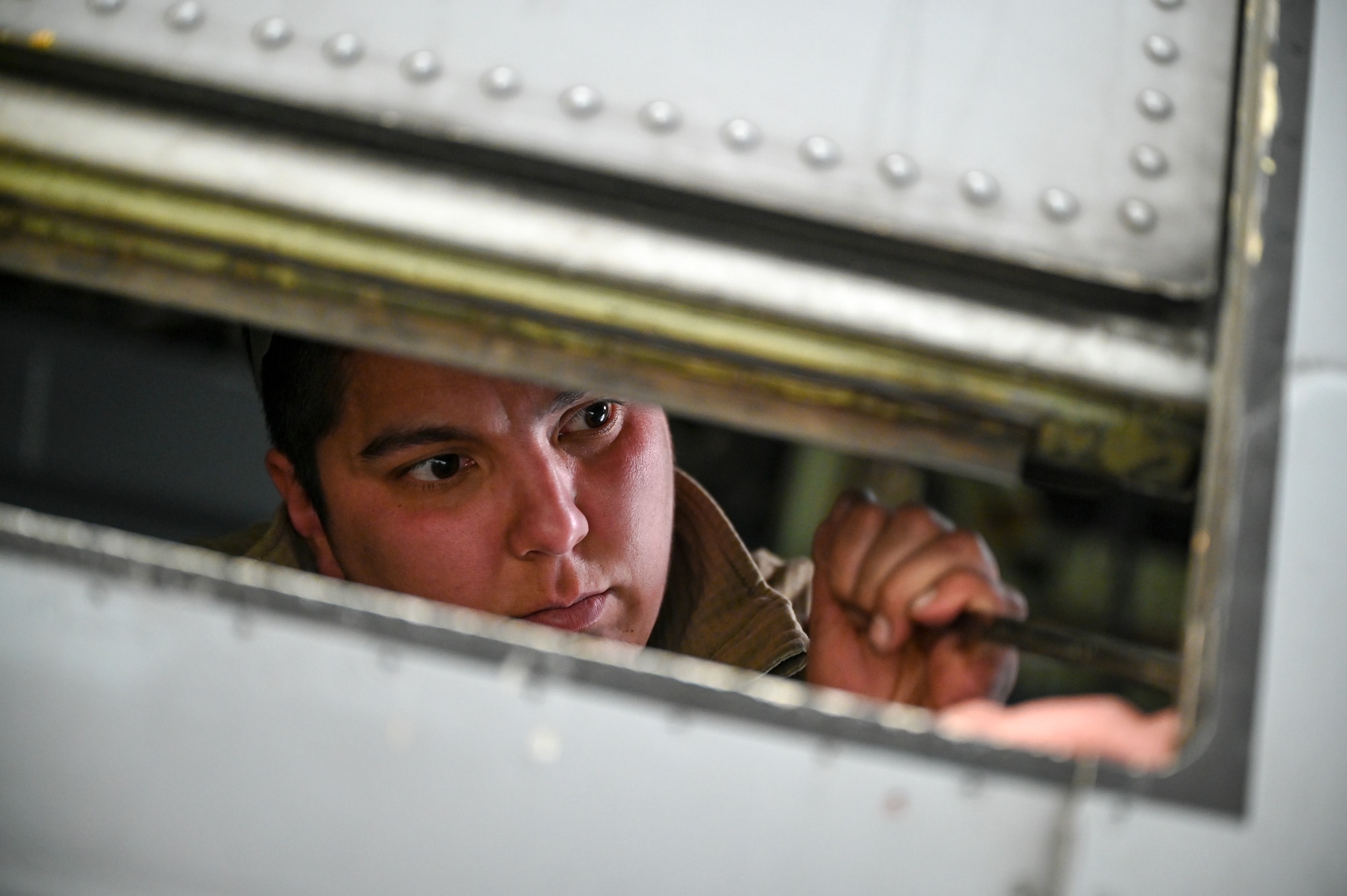 Senior Airman Khala Walls, an aerospace maintainer with the 910th Maintenance Squadron, installs an aerial spray-modified troop door onto a C-130J-30 Super Hercules aircraft from Keesler Air Force Base, Mississippi, visiting Youngstown Air Reserve Station, Ohio, March 19, 2024.