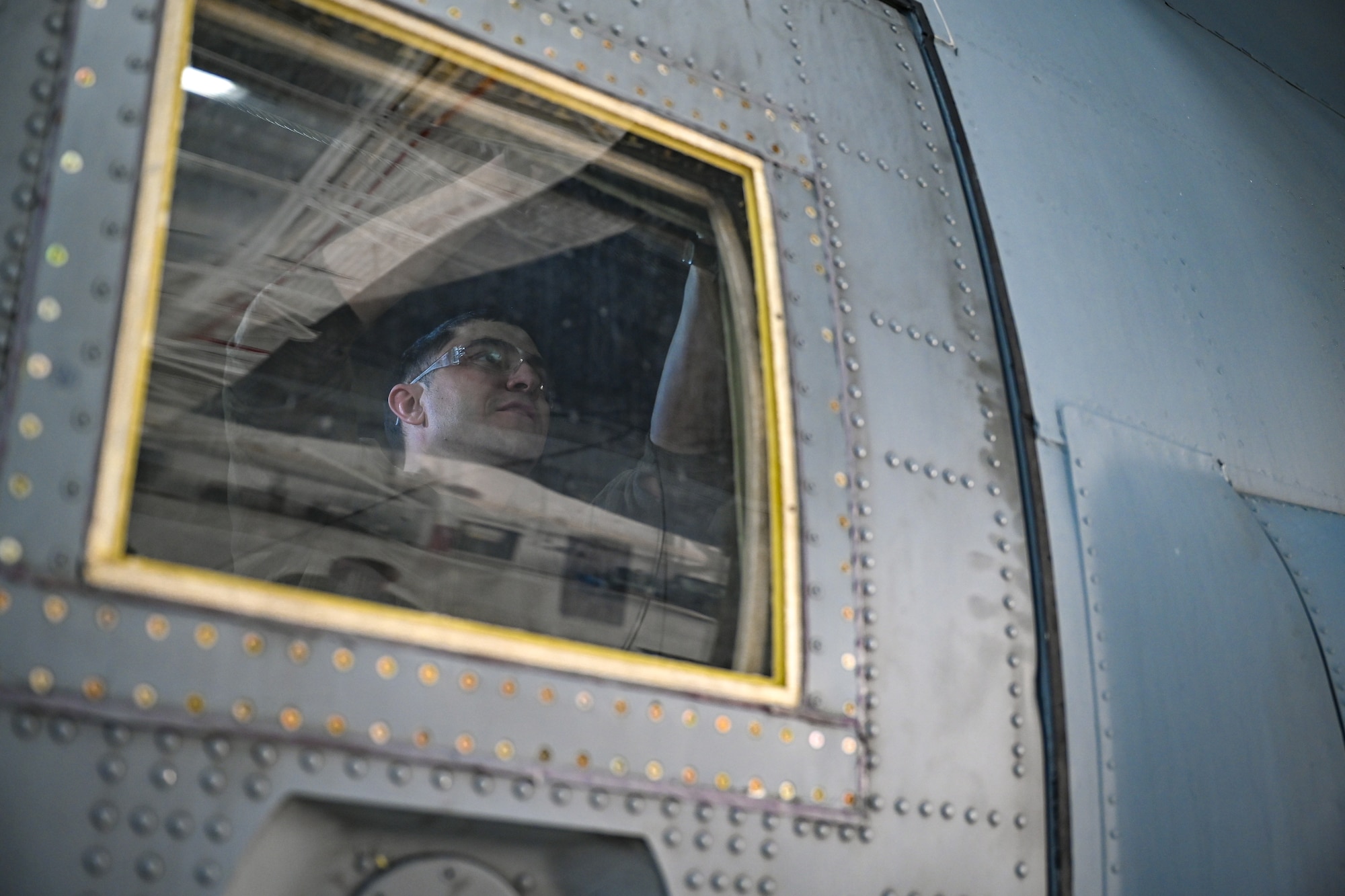 Master Sgt. Jeff McGhee, an aerospace maintainer with the 910th Maintenance Squadron, installs an aerial spray-modified troop door onto a C-130J-30 Super Hercules aircraft from Keesler Air Force Base, Mississippi, visiting Youngstown Air Reserve Station, Ohio, March 19, 2024.