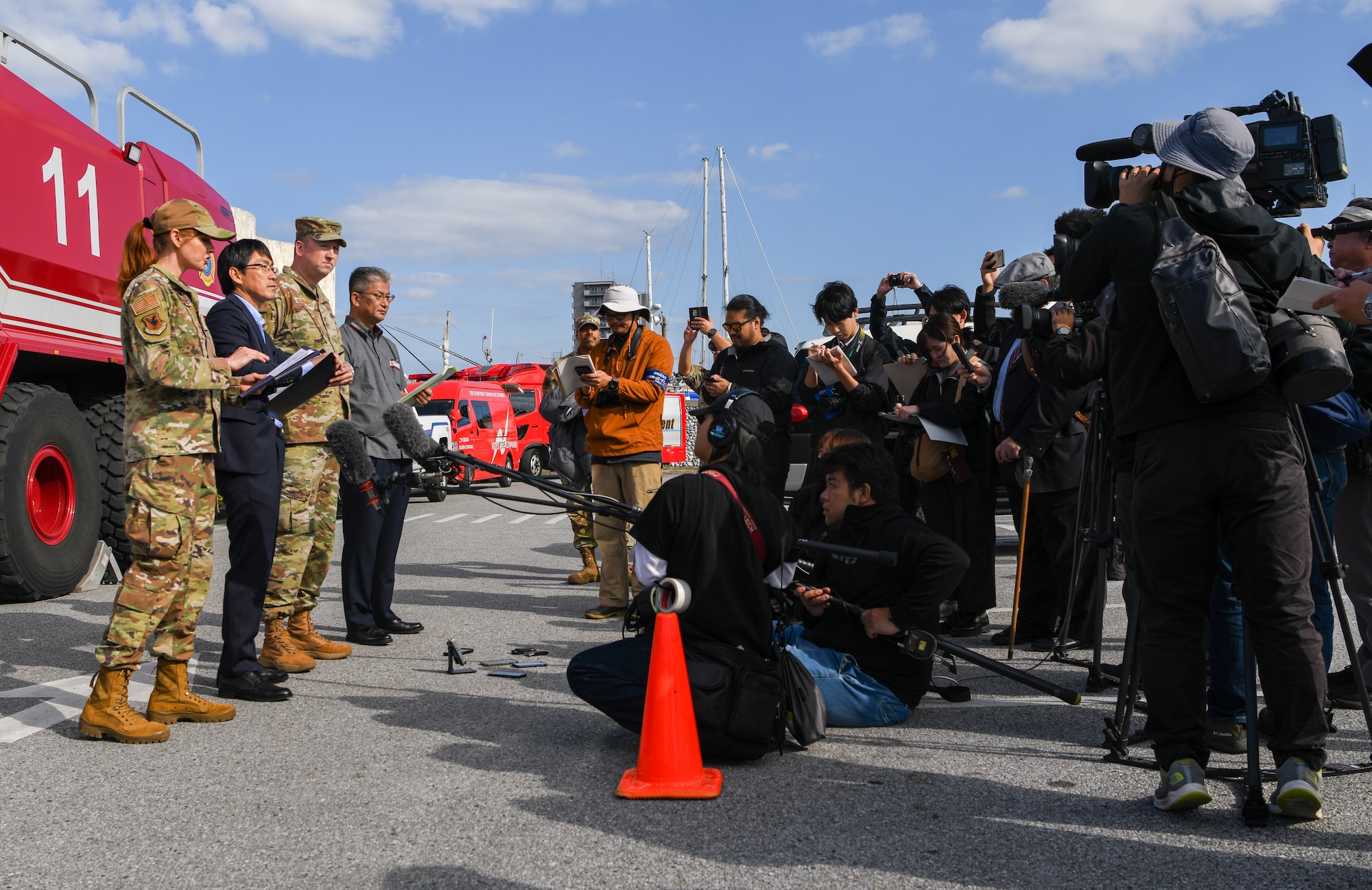U.S. Air Force service members and Teruhiko Moriwaki, Director for Crisis Management  in Okinawa, conduct an interview with media outlets.